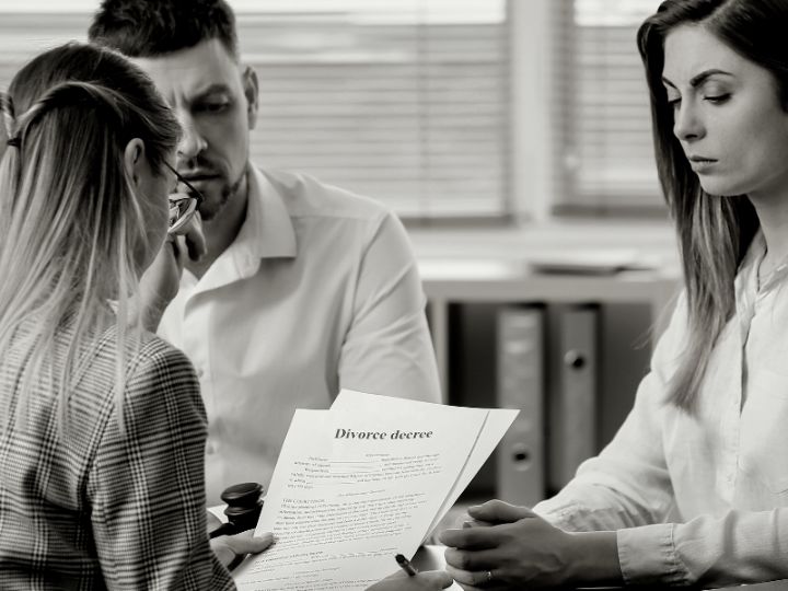 Two individuals in a discussion with one holding a Fairway Divorce Solutions document.