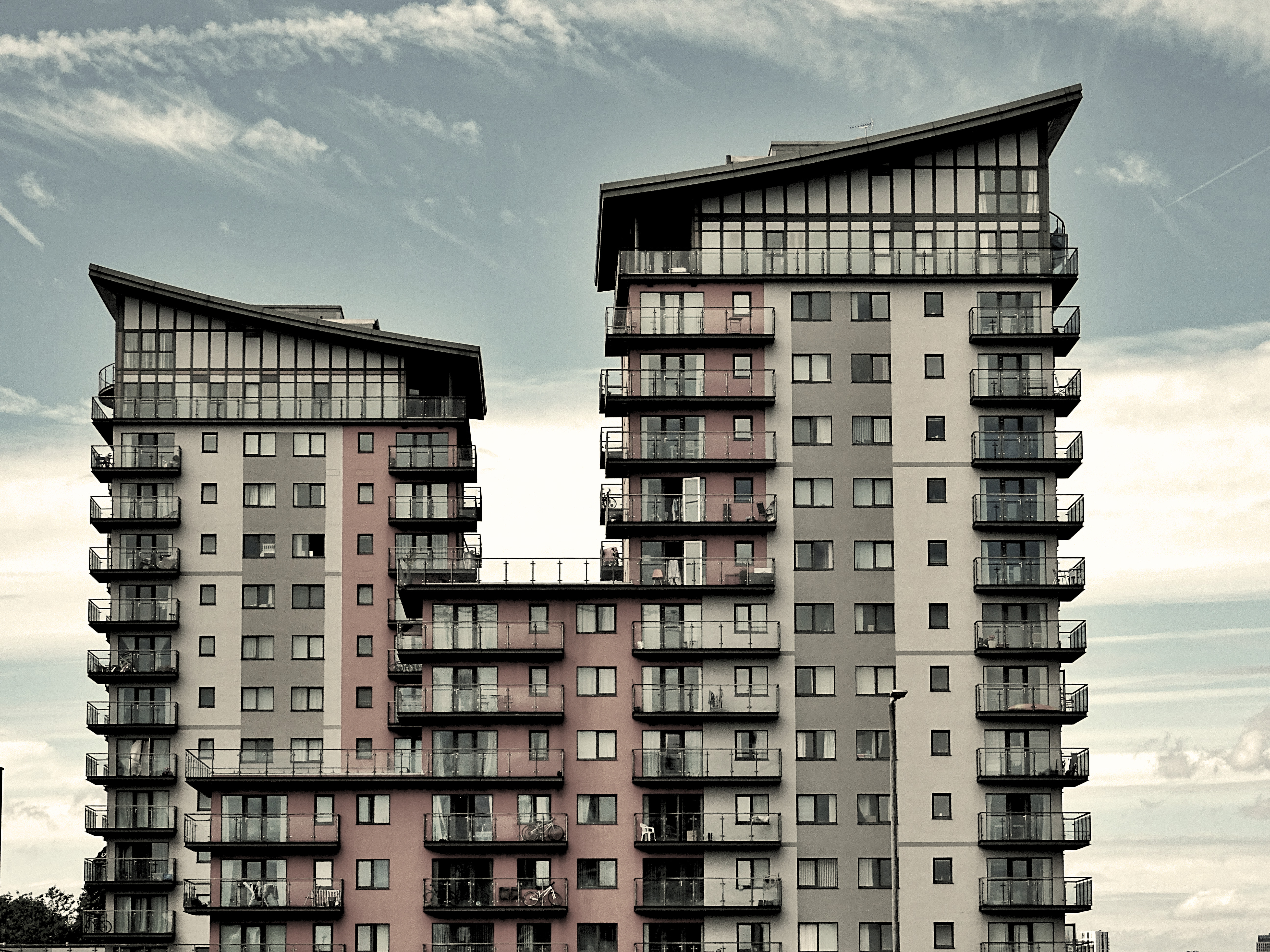 Apartment block with two connected towers on a partly cloudy day