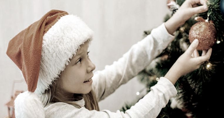 a child decorating the Christmas tree