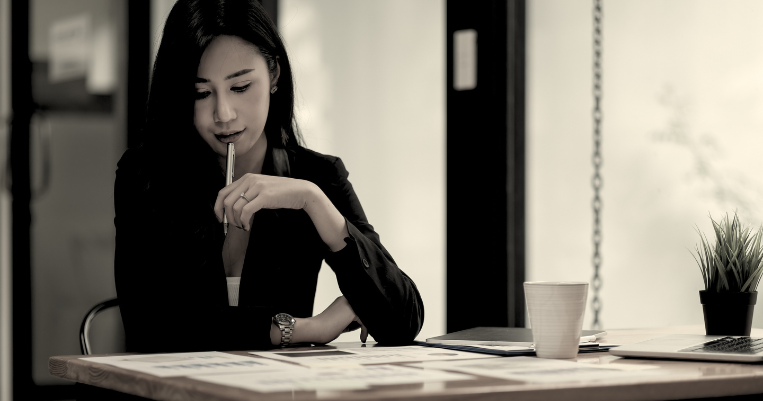 Woman looking over financial documents spread out on a table