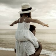 a child sitting on her father's shoulders