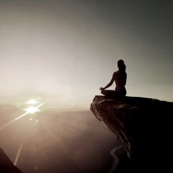 a woman sitting on the top of the mountain